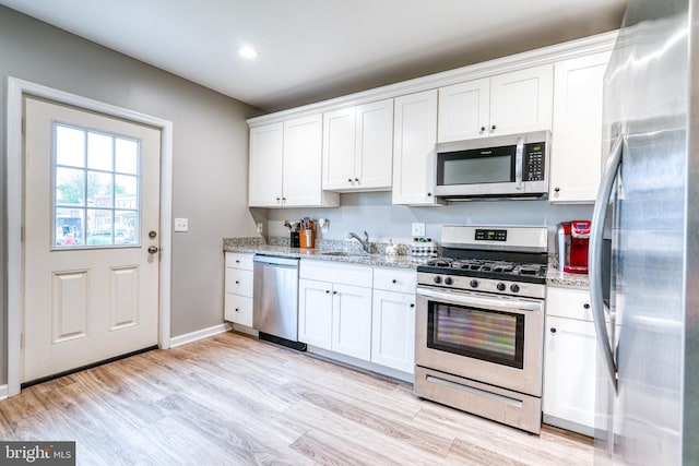 303 Lincoln Ave, Bristol, PA 19007 - kitchen with stainless steel appliances, white cabinets, light stone countertops, light wood-type flooring, and recessed lighting