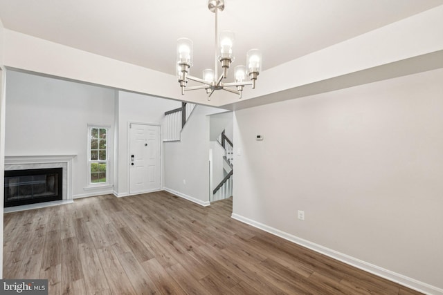 1544 Ingram Ter, Silver Spring, MD 20906 - unfurnished living room featuring wood finished floors, a chandelier, a high end fireplace, and stairway