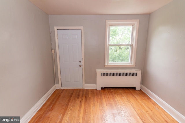3116 Presstman St, Baltimore, MD 21216 - spare room featuring radiator heating unit and light wood-style floors