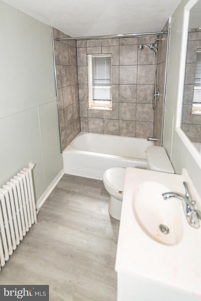 3116 Presstman St, Baltimore, MD 21216 - full bathroom with radiator heating unit, bathtub / shower combination, wood finished floors, and vanity
