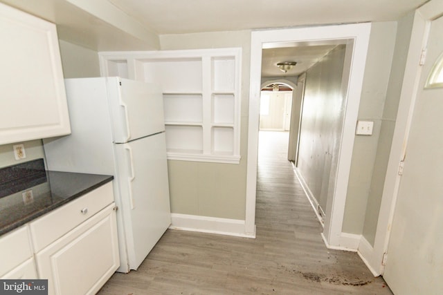 3116 Presstman St, Baltimore, MD 21216 - kitchen featuring light wood-type flooring, freestanding refrigerator, white cabinetry, and dark stone countertops