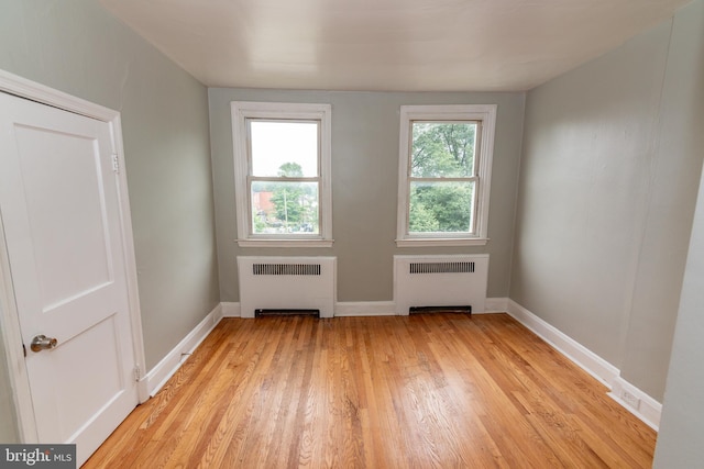 3116 Presstman St, Baltimore, MD 21216 - empty room featuring radiator heating unit and light wood-style floors