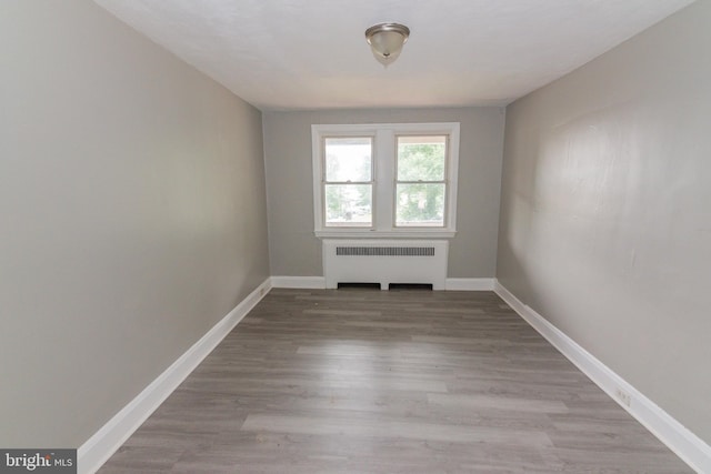 3116 Presstman St, Baltimore, MD 21216 - empty room with radiator and wood finished floors