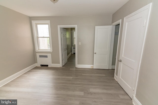3116 Presstman St, Baltimore, MD 21216 - unfurnished bedroom with radiator, light wood-style floors, and ensuite bath