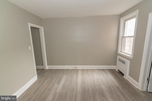 3116 Presstman St, Baltimore, MD 21216 - empty room featuring radiator heating unit and light wood finished floors