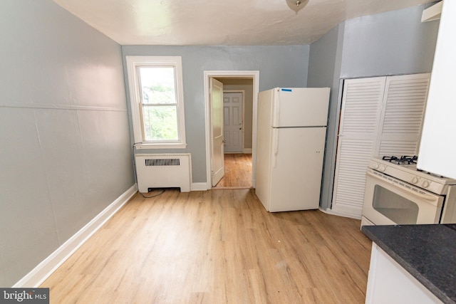 3116 Presstman St, Baltimore, MD 21216 - kitchen with white appliances, radiator heating unit, light wood-type flooring, and dark countertops