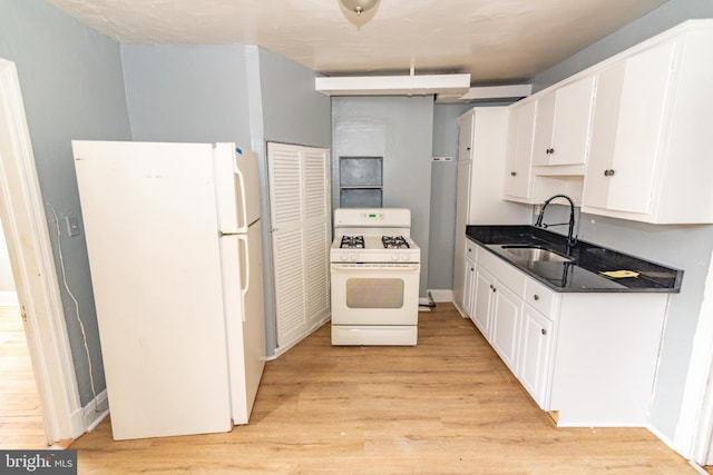 3116 Presstman St, Baltimore, MD 21216 - kitchen featuring white appliances, white cabinetry, light wood-style floors, and dark stone countertops