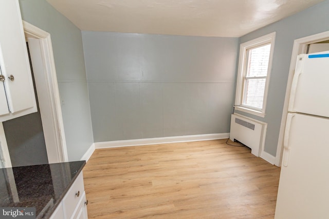 3116 Presstman St, Baltimore, MD 21216 - unfurnished dining area with radiator heating unit and light wood-style floors