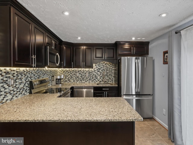 7313 Husky Ln, Springfield, VA 22151 - kitchen with stainless steel appliances, backsplash, dark brown cabinetry, light stone counters, and recessed lighting