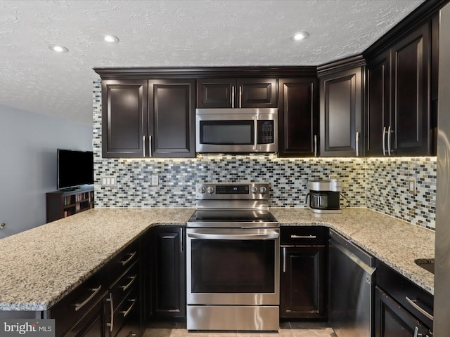 7313 Husky Ln, Springfield, VA 22151 - kitchen featuring stainless steel appliances, a textured ceiling, tasteful backsplash, a peninsula, and light stone countertops