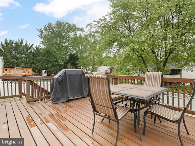 7313 Husky Ln, Springfield, VA 22151 - wooden deck with outdoor dining space, view of scattered trees, and a grill