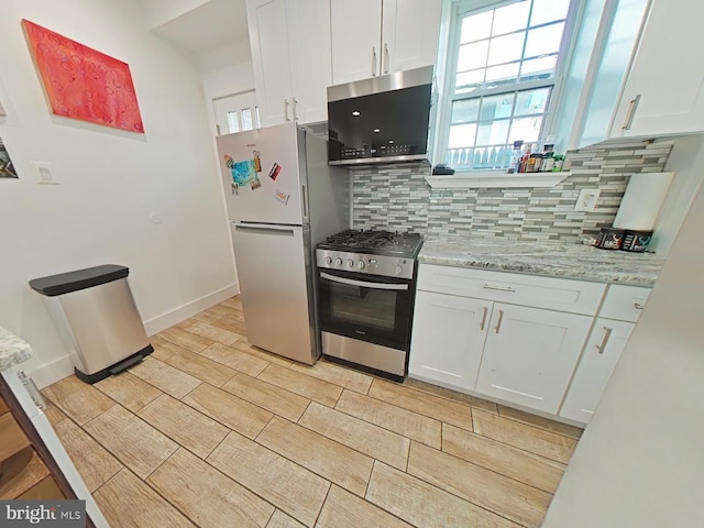 2230 N Mutter St, Philadelphia, PA 19133 - kitchen featuring freestanding refrigerator, stainless steel range with gas cooktop, backsplash, white cabinetry, and plenty of natural light