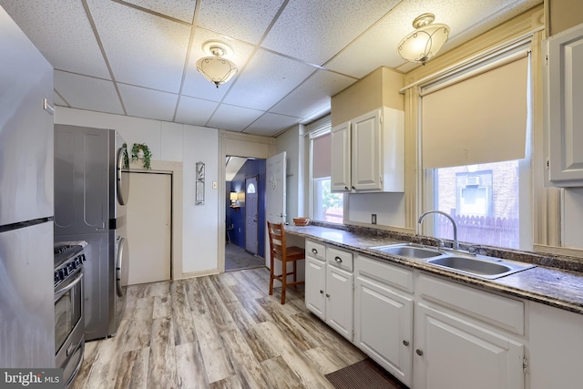48 Ranck Ave, Lancaster, PA 17602 - kitchen with estacked washer and dryer, appliances with stainless steel finishes, a paneled ceiling, dark countertops, and light wood finished floors