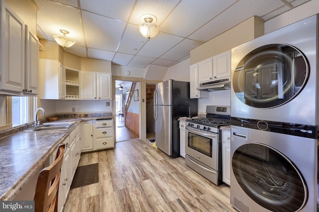 48 Ranck Ave, Lancaster, PA 17602 - kitchen featuring stainless steel appliances, a paneled ceiling, stacked washing machine and dryer, under cabinet range hood, and open shelves