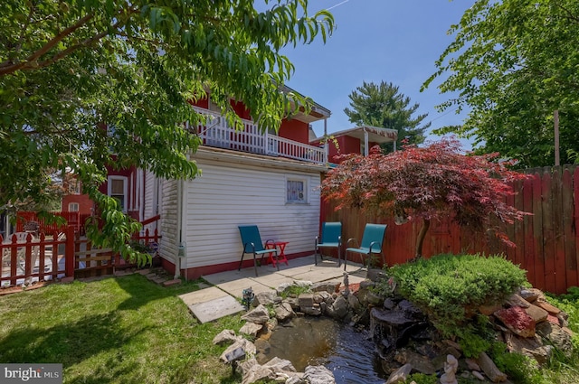 48 Ranck Ave, Lancaster, PA 17602 - rear view of property featuring a balcony, a patio area, and a small pond