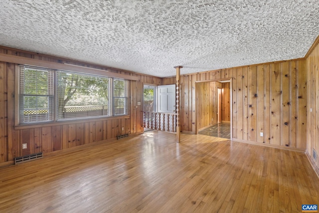 1562 Thomas Jefferson Pkwy, Charlottesville, VA 22901 - spare room featuring hardwood / wood-style flooring, wooden walls, and a textured ceiling