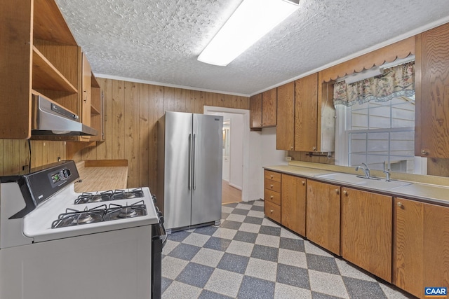 1562 Thomas Jefferson Pkwy, Charlottesville, VA 22901 - kitchen with white range with gas cooktop, freestanding refrigerator, under cabinet range hood, dark flooring, and wood walls