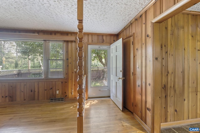 1562 Thomas Jefferson Pkwy, Charlottesville, VA 22901 - doorway to outside featuring wood walls, light wood-type flooring, a textured ceiling, and ornamental molding