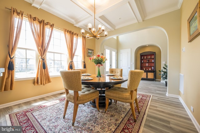 5745 Hawk Ridge Rd, Frederick, MD 21704 - dining space featuring arched walkways, coffered ceiling, a chandelier, light wood-style flooring, and beamed ceiling