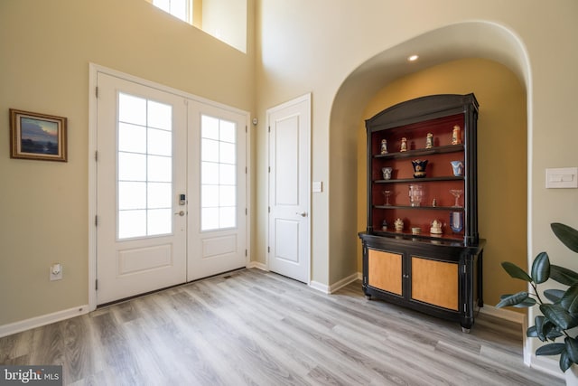 5745 Hawk Ridge Rd, Frederick, MD 21704 - foyer with arched walkways, french doors, light wood finished floors, and a high ceiling