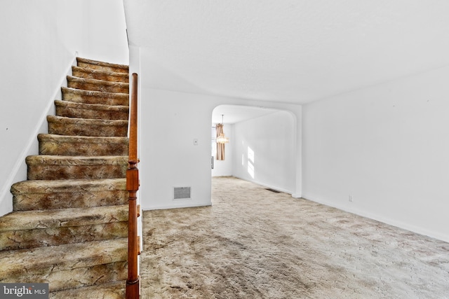 6344 Glenloch St, Philadelphia, PA 19135 - staircase featuring arched walkways and carpet floors
