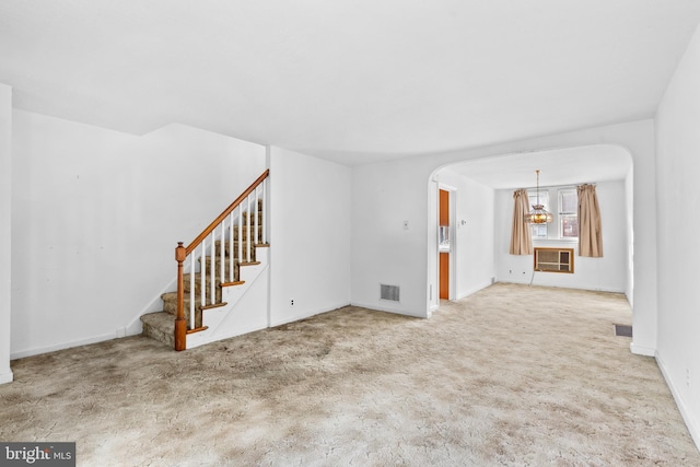 6344 Glenloch St, Philadelphia, PA 19135 - unfurnished living room featuring stairway, carpet flooring, arched walkways, and a chandelier
