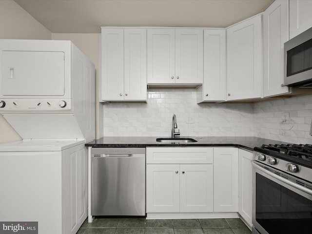 18615 Walkers Choice Rd # 2, Gaithersburg, MD 20886 - kitchen featuring appliances with stainless steel finishes, stacked washer and clothes dryer, white cabinetry, and backsplash