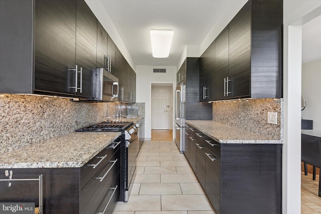 191 Presidential Blvd Unit R-605, Bala Cynwyd, PA 19004 - kitchen featuring stainless steel appliances, backsplash, modern cabinets, light tile patterned floors, and light stone countertops