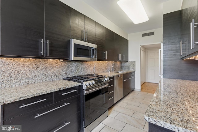 191 Presidential Blvd Unit R-605, Bala Cynwyd, PA 19004 - kitchen with stainless steel appliances, backsplash, light tile patterned floors, and dark cabinetry