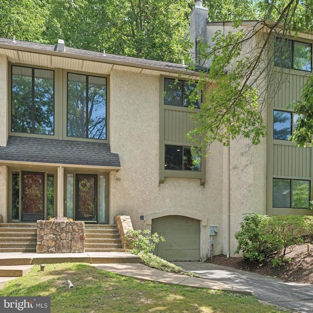 500 Lynetree Dr Unit 1-C, West Chester, PA 19380 - mid-century home featuring an attached garage, stucco siding, concrete driveway, and a chimney