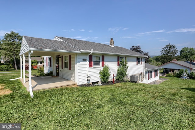 101 Walton Ave, Carlisle, PA 17013 - rear view of house with a chimney, a lawn, a shingled roof, and a sunroom