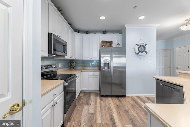 37 Fountain Dr W Unit 4C, Ocean City, MD 21842 - kitchen featuring stainless steel appliances, crown molding, white cabinets, light countertops, and light wood finished floors
