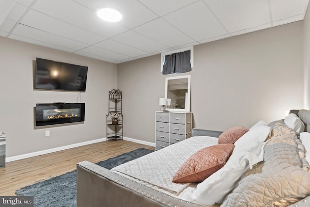 3404 Citation Dr, Harrisburg, PA 17112 - bedroom featuring wood finished floors, a drop ceiling, and a glass covered fireplace