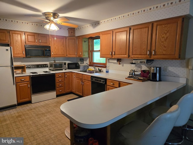 526 Fairground Rd, Newport, PA 17074 - kitchen featuring black appliances, wallpapered walls, light flooring, ceiling fan, and brown cabinetry