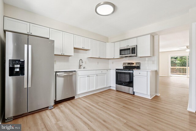 10779 Cordage Walk, Columbia, MD 21044 - kitchen with stainless steel appliances, light wood-style flooring, light countertops, tasteful backsplash, and white cabinets