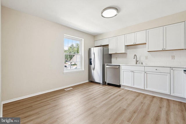 10779 Cordage Walk, Columbia, MD 21044 - kitchen with appliances with stainless steel finishes, light wood finished floors, light countertops, backsplash, and white cabinetry