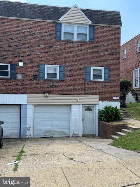 724 Susquehanna Rd, Philadelphia, PA 19111 - view of front of property featuring a garage, driveway, brick siding, and roof with shingles