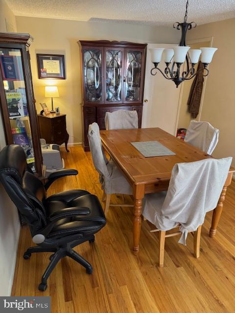 724 Susquehanna Rd, Philadelphia, PA 19111 - dining area featuring a chandelier, a textured ceiling, and light wood-type flooring