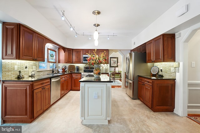 616 Silverstone Ct, Silver Spring, MD 20905 - kitchen with appliances with stainless steel finishes, dark countertops, arched walkways, decorative backsplash, and a kitchen island