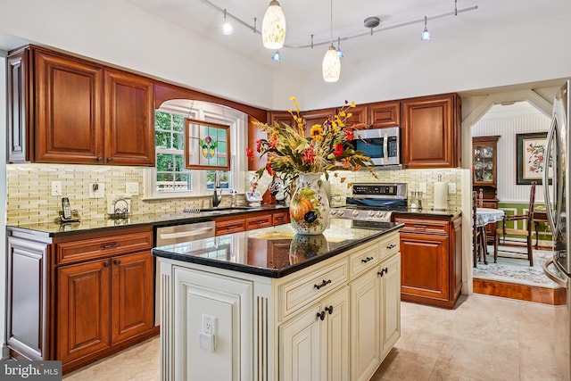 616 Silverstone Ct, Silver Spring, MD 20905 - kitchen featuring stainless steel appliances, cream cabinets, dark stone countertops, tasteful backsplash, and track lighting