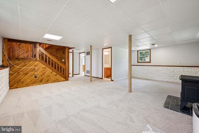 112 Tennessee Trl, Browns Mills, NJ 08015 - below grade area featuring a wood stove, a drop ceiling, carpet floors, stairway, and wooden walls