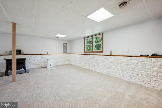 112 Tennessee Trl, Browns Mills, NJ 08015 - basement with a drop ceiling, carpet floors, a wainscoted wall, a wood stove, and electric panel