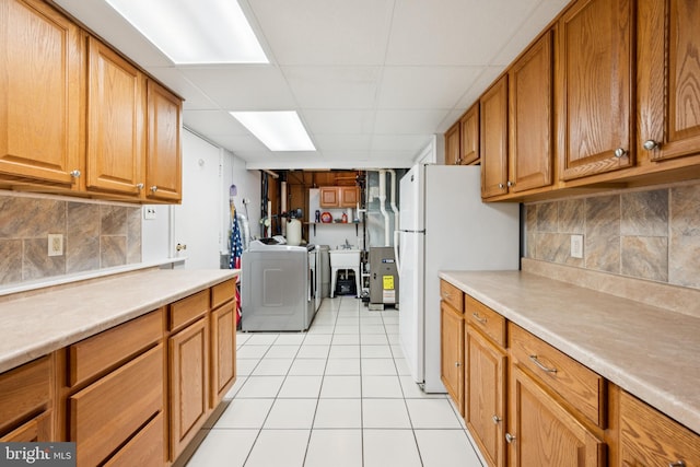 112 Tennessee Trl, Browns Mills, NJ 08015 - kitchen with washer and dryer, freestanding refrigerator, light countertops, brown cabinets, and a drop ceiling