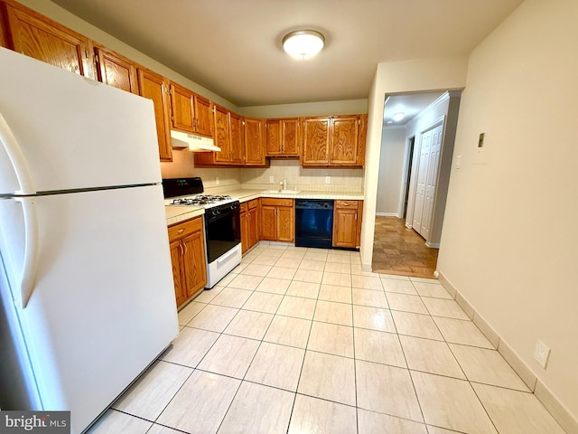 868 Quince Orchard Blvd Unit 202, Gaithersburg, MD 20878 - kitchen featuring white appliances, under cabinet range hood, light countertops, light tile patterned floors, and tasteful backsplash