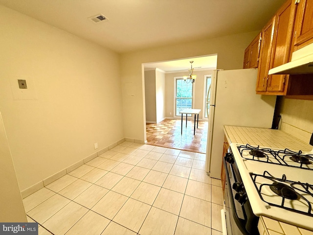 868 Quince Orchard Blvd Unit 202, Gaithersburg, MD 20878 - kitchen featuring white gas stove, brown cabinets, light countertops, and a chandelier