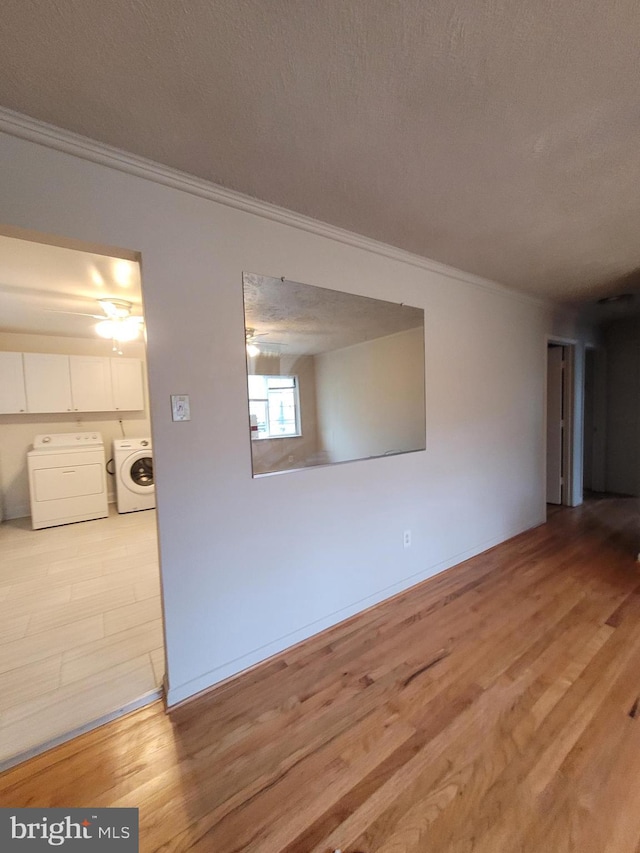 244 6th St, Colonial Beach, VA 22443 - unfurnished room featuring ornamental molding, light wood-style flooring, washing machine and dryer, and a textured ceiling