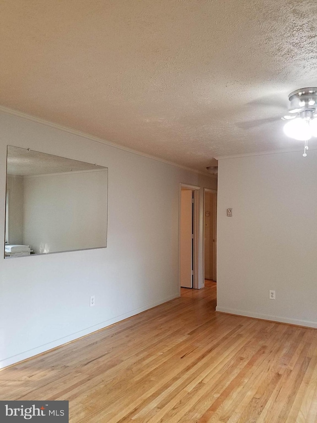 244 6th St, Colonial Beach, VA 22443 - empty room featuring a textured ceiling, light wood-style floors, and ornamental molding