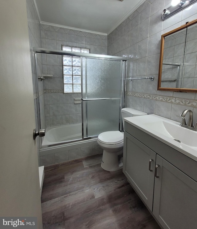 244 6th St, Colonial Beach, VA 22443 - bathroom with tile walls, wood finished floors, ornamental molding, vanity, and tiled shower / bath combo
