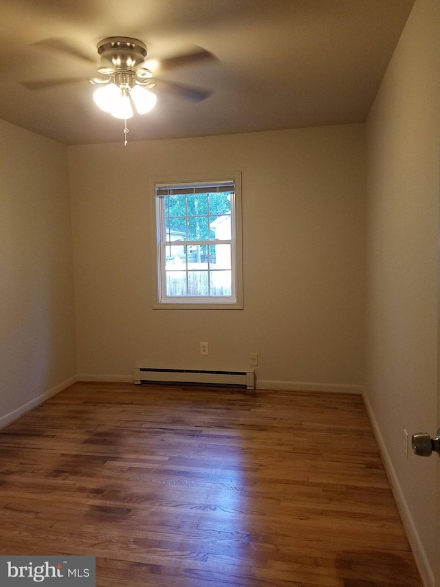 244 6th St, Colonial Beach, VA 22443 - unfurnished room featuring a baseboard heating unit, wood finished floors, and a ceiling fan