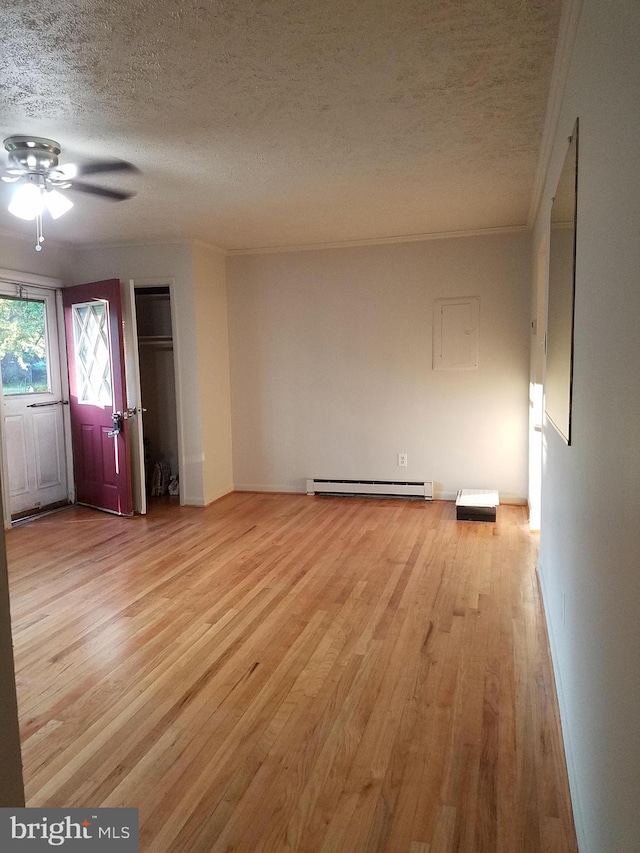 244 6th St, Colonial Beach, VA 22443 - unfurnished living room with a textured ceiling, baseboard heating, ornamental molding, light wood-type flooring, and ceiling fan